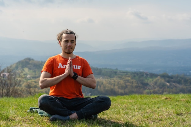 Jonge man mediteert yoga op de rotspiek Ontspan en kalm?