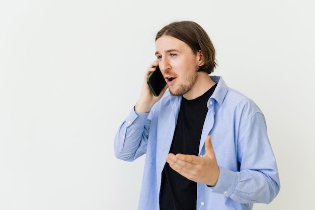 Jonge man met baard lopend en pratend met mobiele telefoon