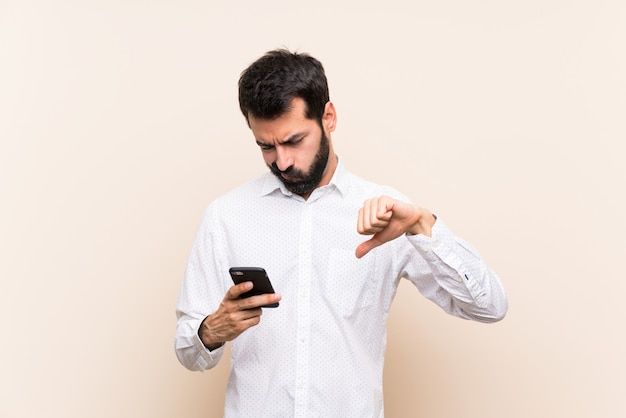 Jonge man met baard met een mobiele duim tonen