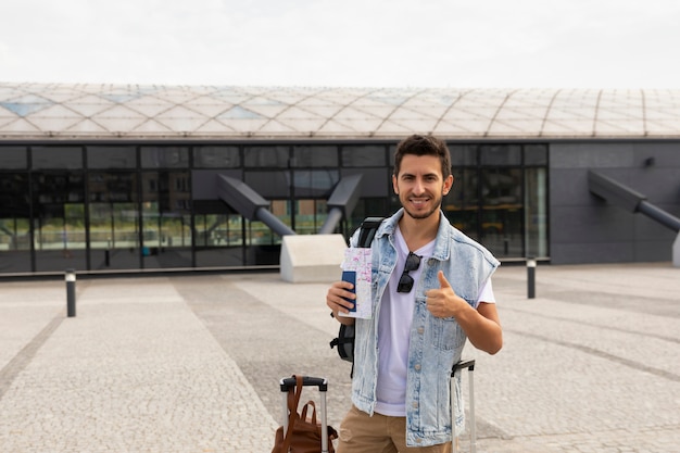 Jonge man met bagage op het treinstation