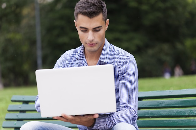 Jonge man met behulp van een laptopcomputer buitenshuis