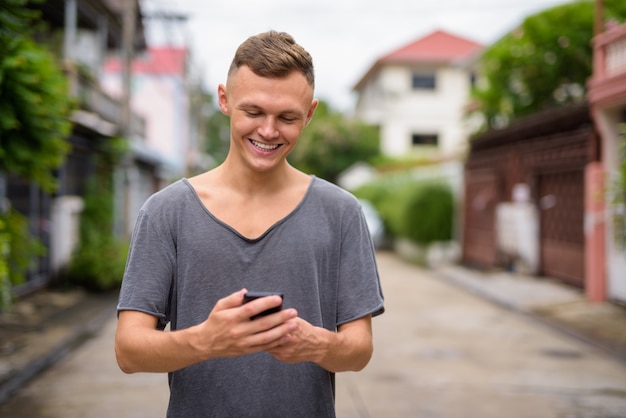 Jonge man met behulp van mobiele telefoon in de straten buiten