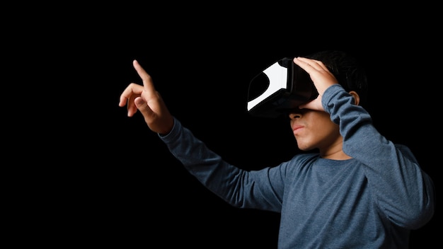 Foto jonge man met behulp van virtual reality headset. vr, toekomst, technologie online concept. donkere achtergrond.