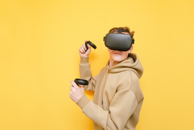 Jonge man met controller in zijn handen en Vr-helm spelen van videogames