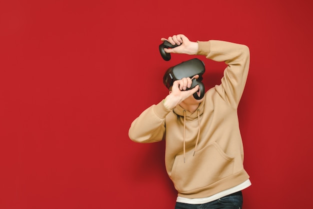 Jonge man met controller in zijn handen en Vr-helm spelen van videogames