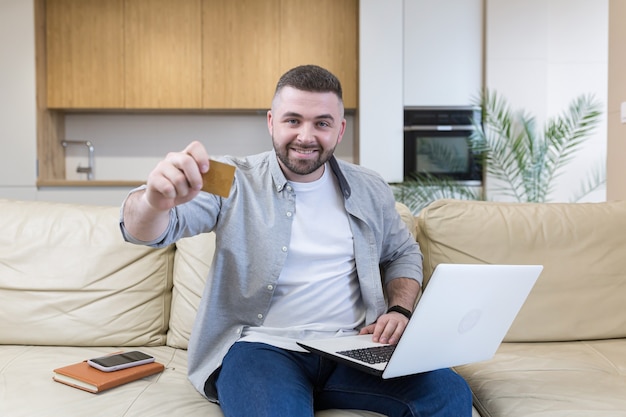 Jonge man met creditcard en het gebruik van telefoon thuis kantoor