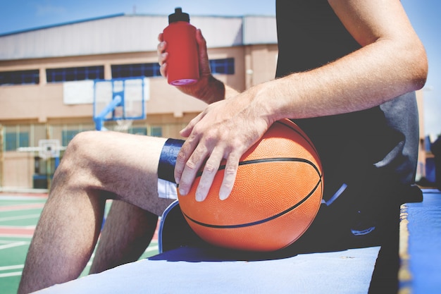 Foto jonge man met de basketbal achter een hek