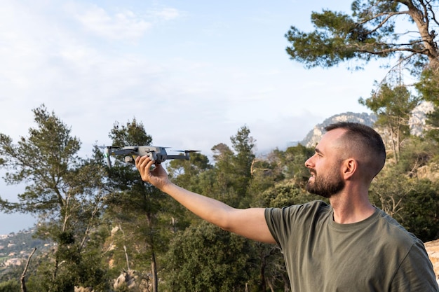 Jonge man met drone voor vlucht in de natuurGuy bereidt zich voor om buiten te vliegen