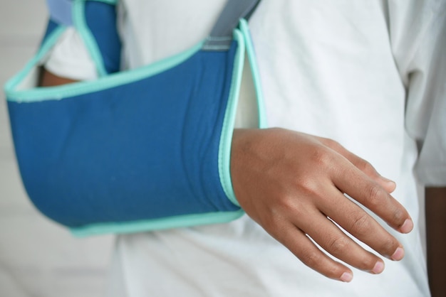 Jonge man met een armbrace voor gebroken hand