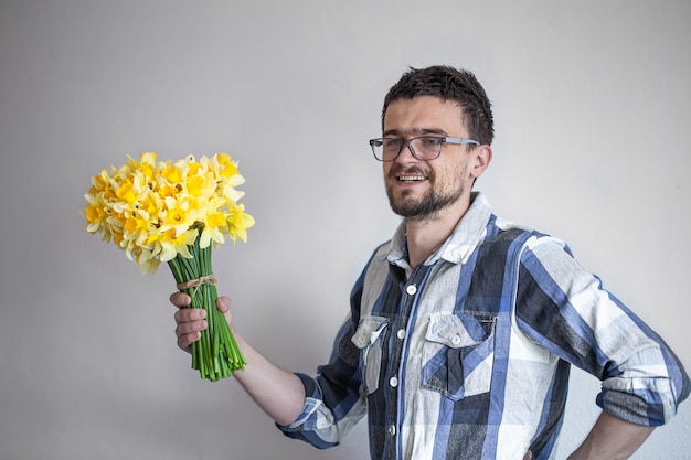 Jonge man met een bril en een boeket bloemen.