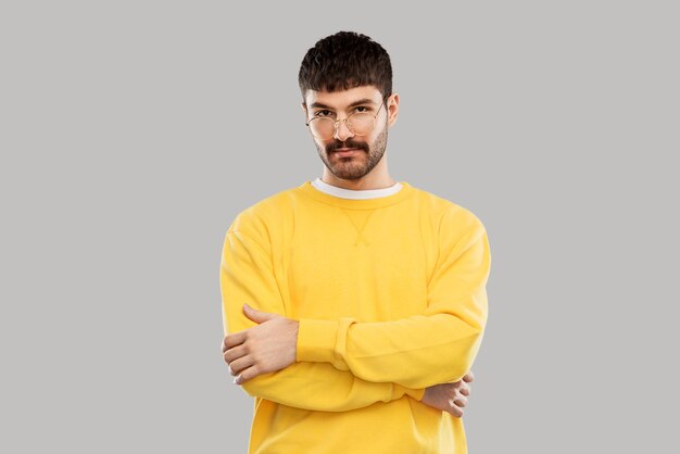 jonge man met een bril en een gele sweatshirt