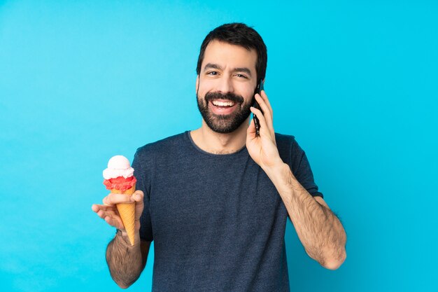 Jonge man met een cornet ijs houden van een gesprek met de mobiele telefoon met iemand