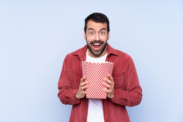 Jonge man met een grote emmer popcorns