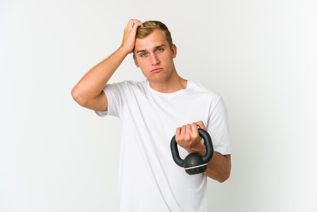 Jonge man met een kettlebell droomt van het bereiken van doelen en doeleinden