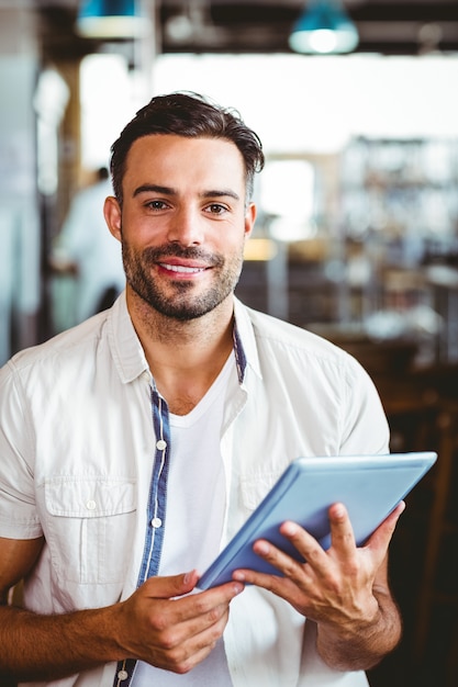 Jonge man met een kopje koffie met behulp van Tablet PC