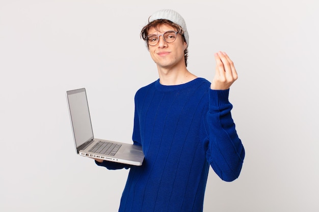 Jonge man met een laptop die capice of geldgebaar maakt en zegt dat je moet betalen