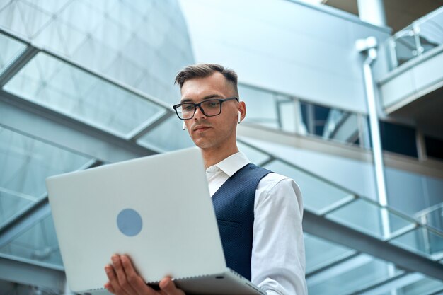 Jonge man met een laptop in een zakencentrum.