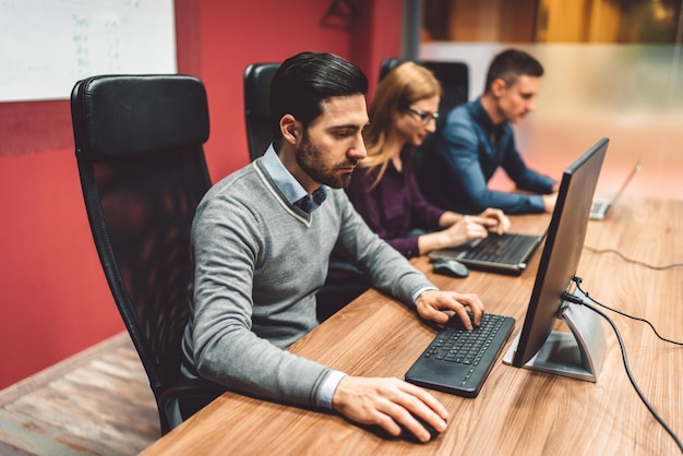 Jonge man met een laptop terwijl hij thuis op de bank zit