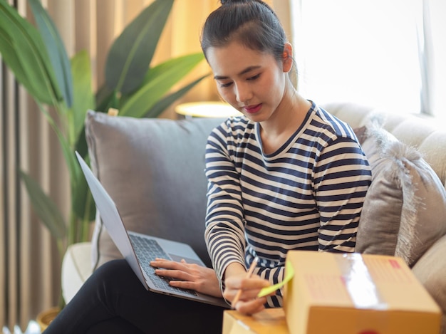 Jonge man met een laptop terwijl hij thuis op de bank zit