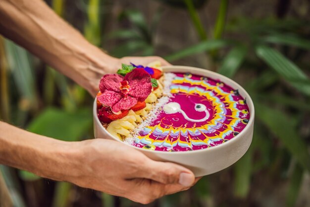 Jonge man met een mediterraan ontbijt eet een gezonde tropische ontbijt smoothie kom met