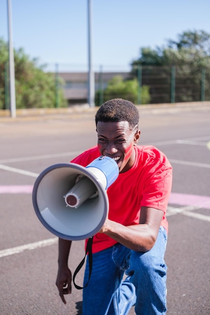 Jonge man met een megafoon die slogans gooit met een dappere houding