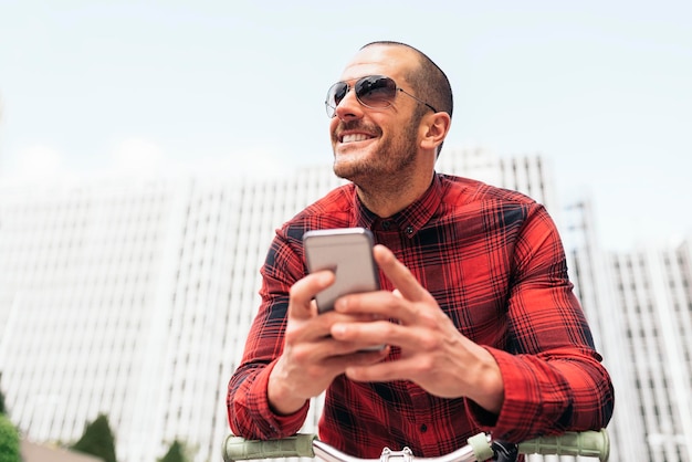 Jonge man met een mobiele telefoon in de stad