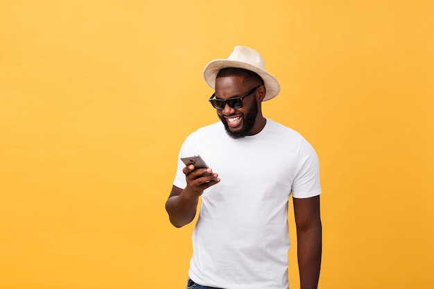 Jonge man met een mobiele telefoon op een gele achtergrond