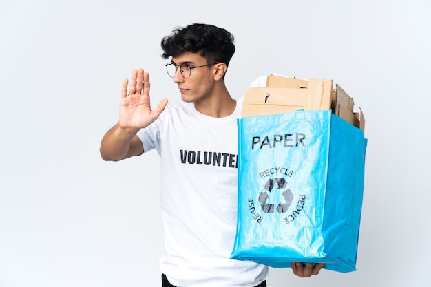 Jonge man met een recycling zak vol papier stop gebaar maken en teleurgesteld