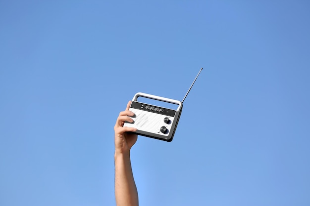 Foto jonge man met een retro-radio op blauwe achtergrond