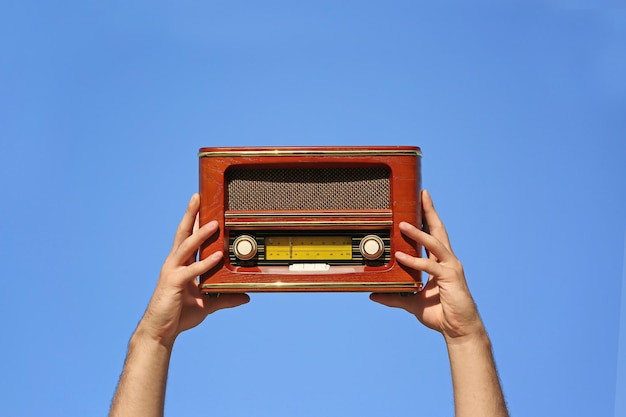 Jonge man met een retro-radio op blauwe achtergrond