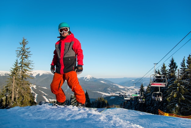 Jonge man met een snowboard op de bergen