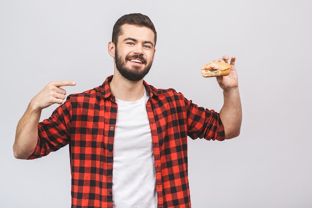 Jonge man met een stuk hamburger. Dieetconcept tegen witte achtergrond wordt geïsoleerd die.