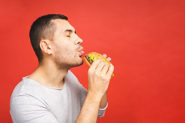 Jonge man met een stuk hamburger