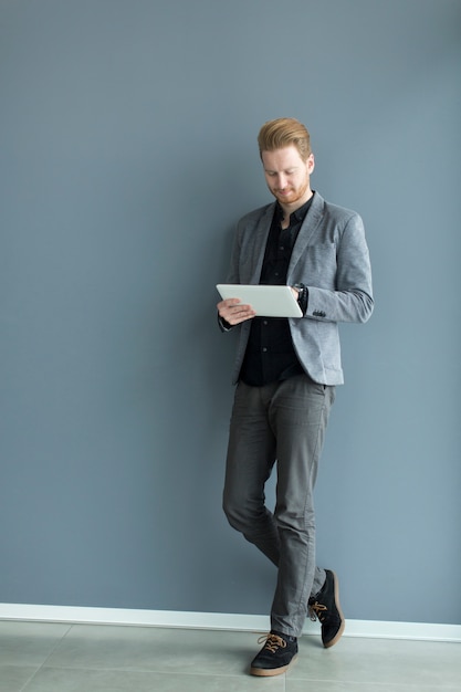 Jonge man met een tablet door de muur