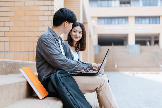 Jonge man met een telefoon terwijl hij op een laptop zit