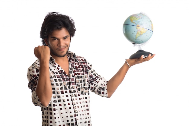 Jonge man met een wereldbol op een witte achtergrond.