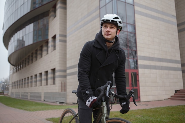 Jonge man met fietshelm tijdens het fietsen door de straten van de stad