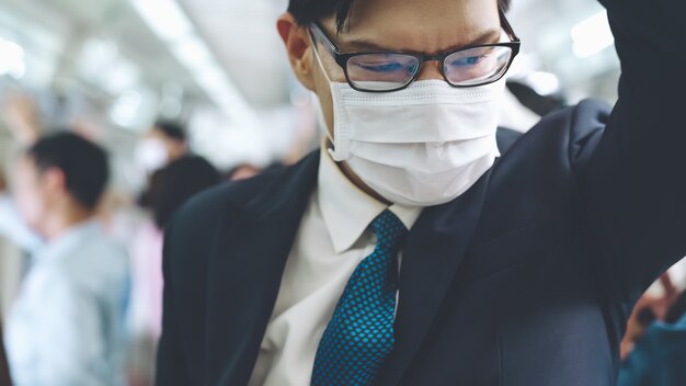 Jonge man met gezichtsmasker reist in overvolle metro