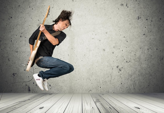 Jonge man met gitaar op achtergrond