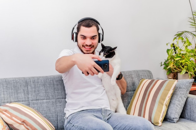 Jonge man met haar kat maakt thuis een selfiefoto