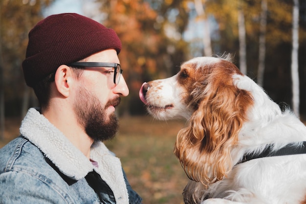 Foto jonge man met hond in het park op een zonnige dag