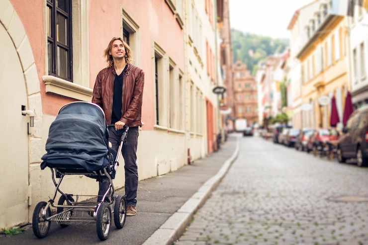 Foto jonge man met kinderwagen die op het trottoir staat