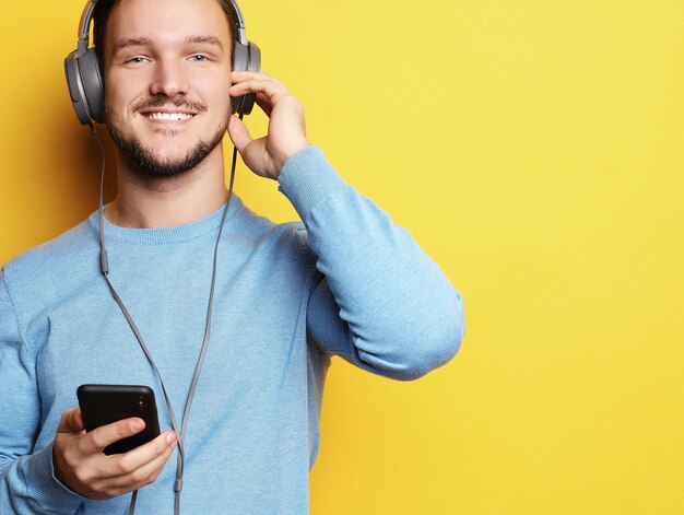 Jonge man met koptelefoon en mobiele telefoon bedrijf