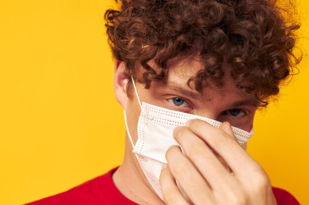 Jonge man met krullend haar in beschermende maskers veiligheid poseren geïsoleerde achtergrond ongewijzigd