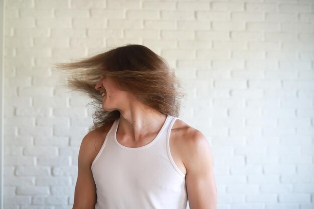 Jonge man met lang haar die met zijn hoofd zwaait