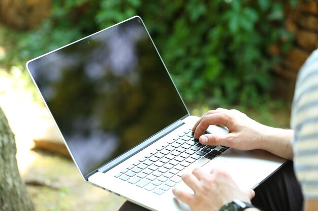 Foto jonge man met laptop buiten