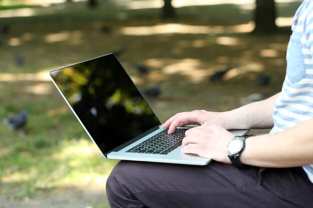 Jonge man met laptop buitenshuis