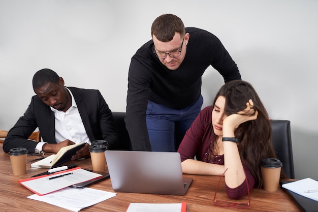 Jonge man met mobiele telefoon terwijl hij op tafel zit