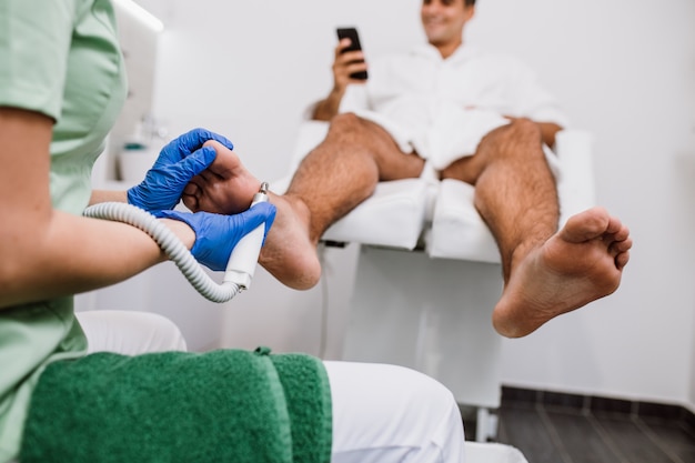 Jonge man met pedicure behandeling in een moderne schoonheidssalon.