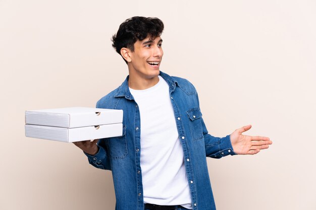 Jonge man met pizza's dozen over geïsoleerde muur